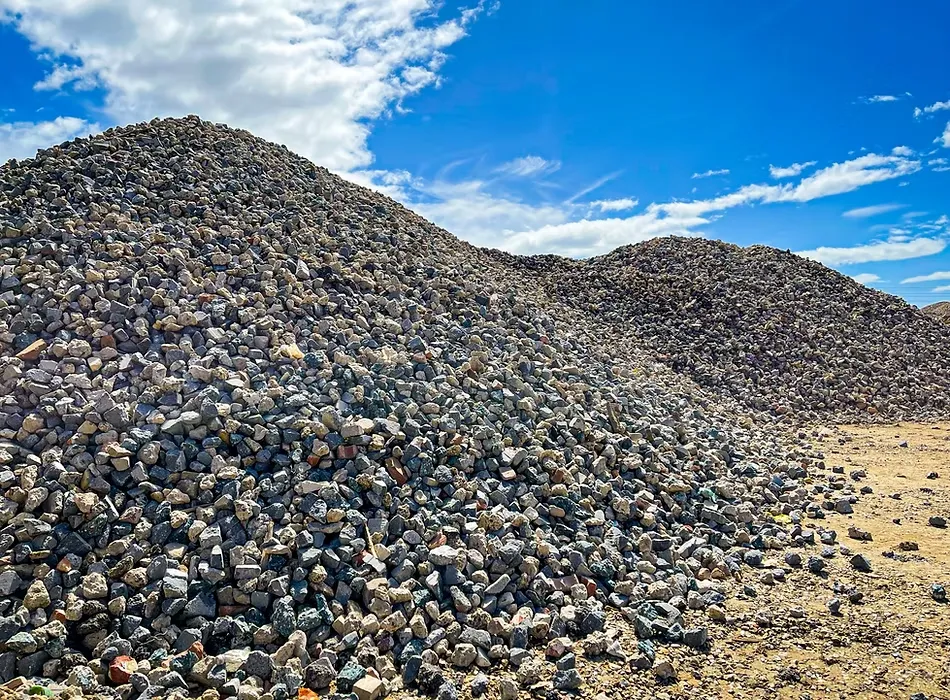 Large piles of J Mould crushed stone aggregate under a blue sky