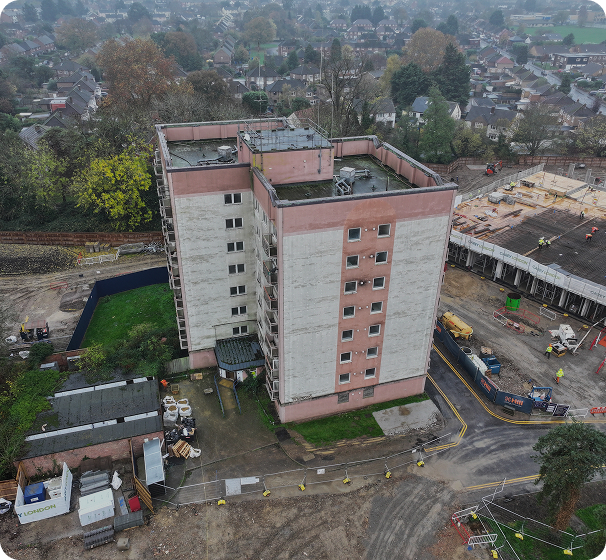 Aerial view of a J Mould tower block demolition beside new homes under construction