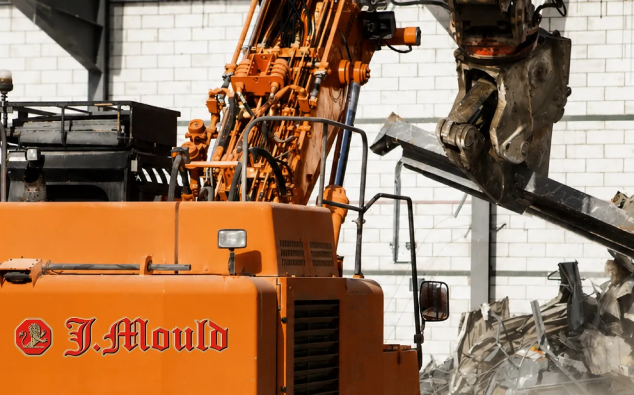 J Mould branded excavator with a demolition shear crushing debris
