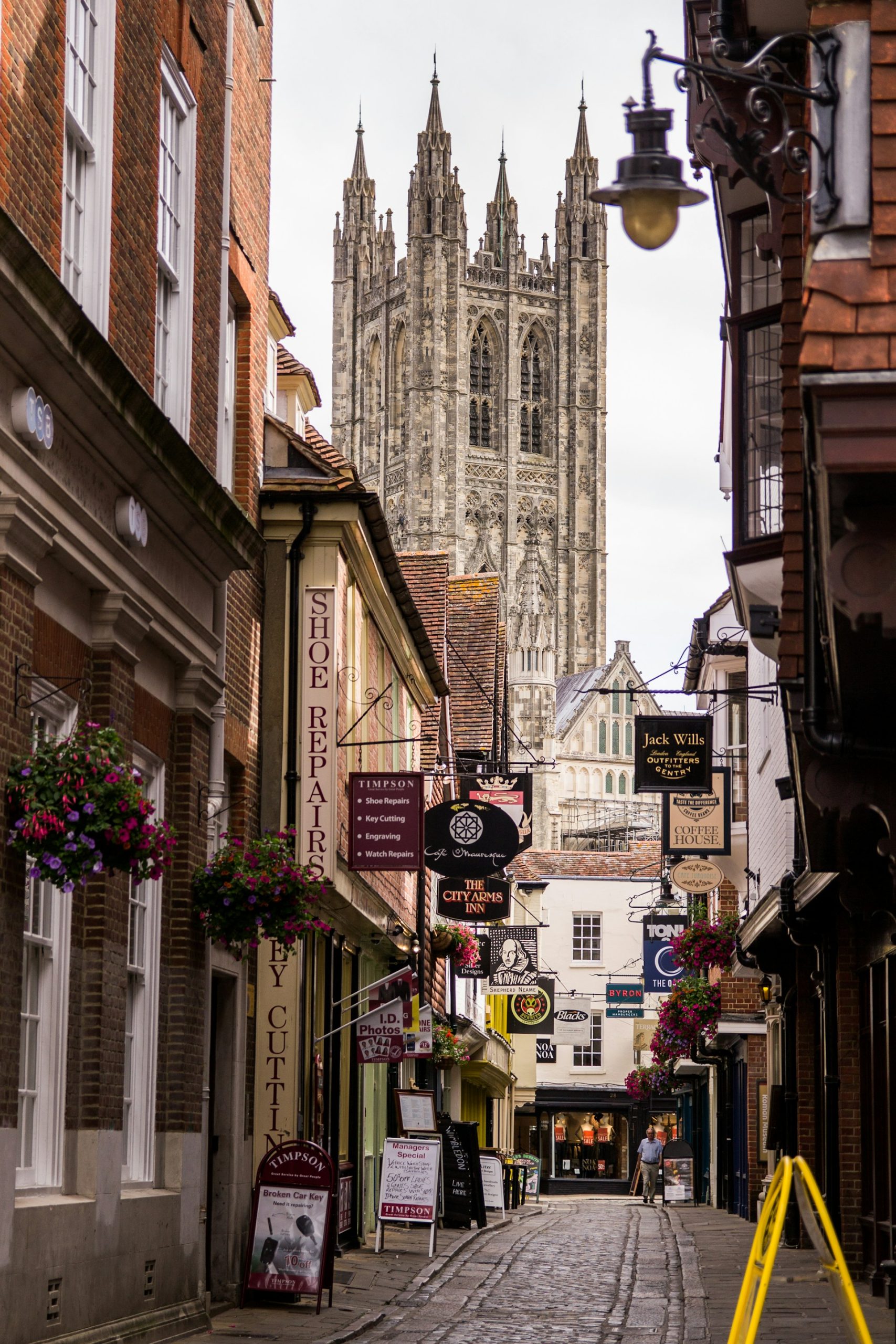 Canterbury Cathedral's Bell Harry Tower above a lane of shops, where J Mould carries out demolition