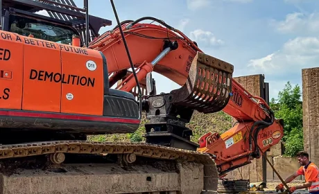 Orange J.Mould excavator with a demolition grapple attachment on site