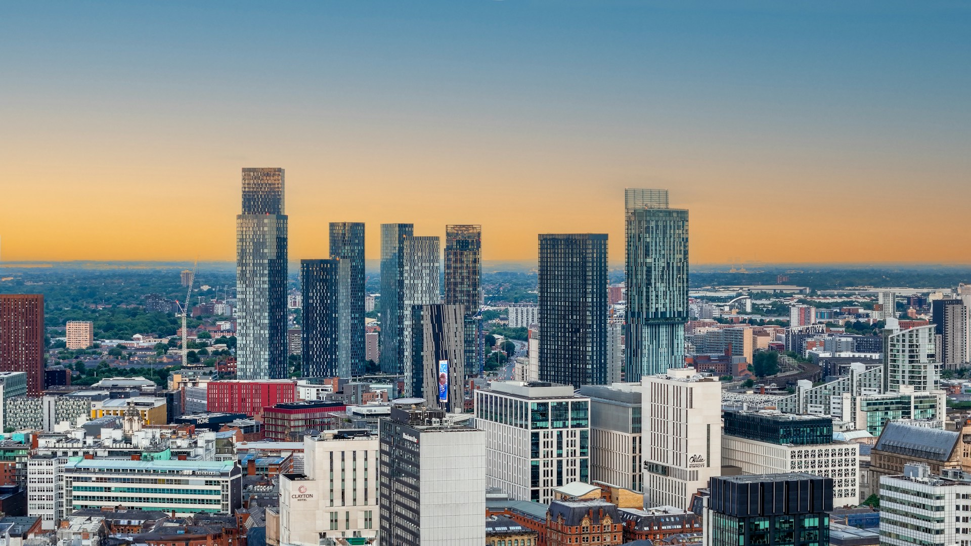 Manchester city centre skyline at sunset with tall glass towers, where J Mould carries out demolition