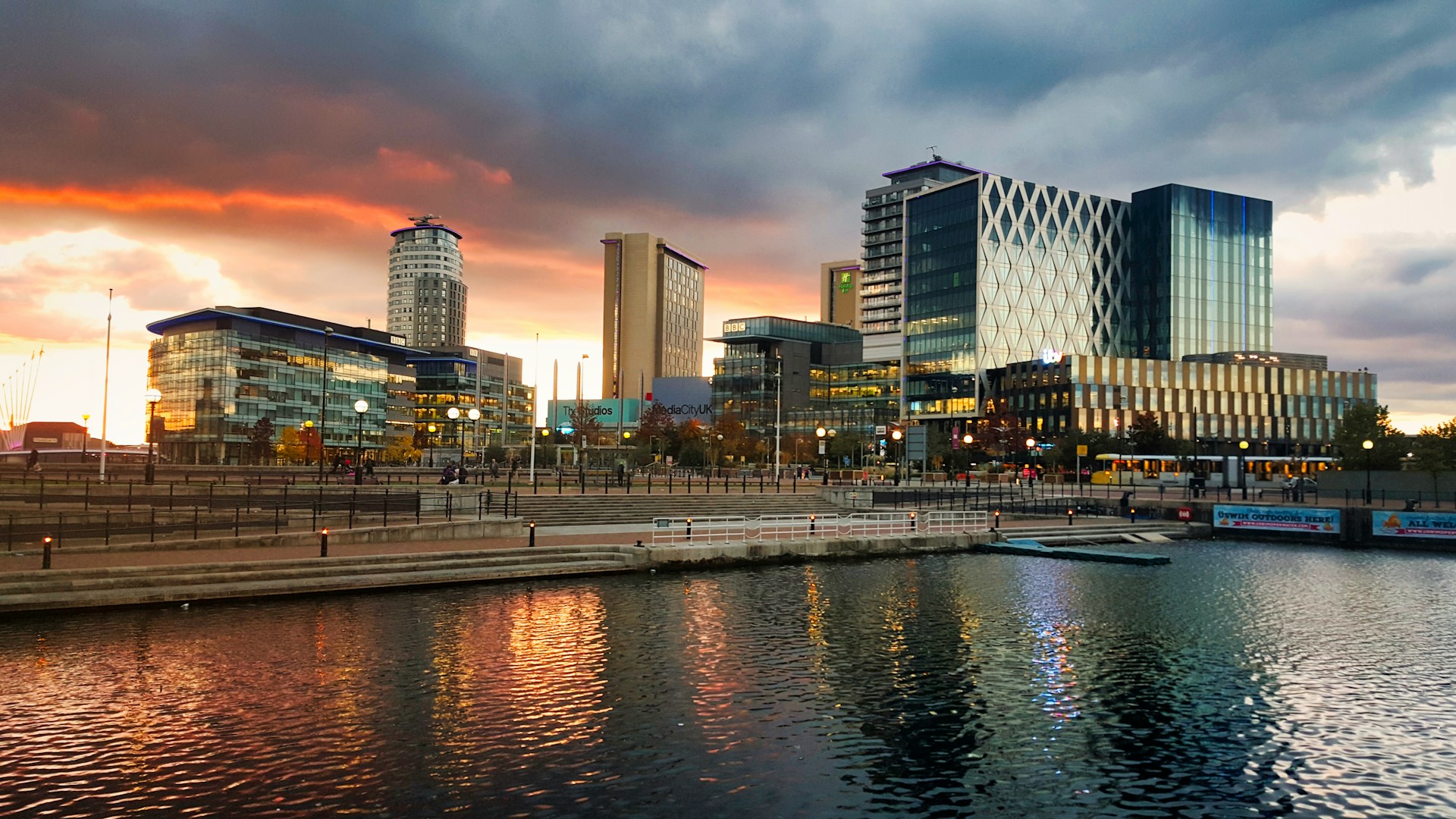MediaCityUK at Salford Quays reflected in the water at sunset, served by J Mould demolition