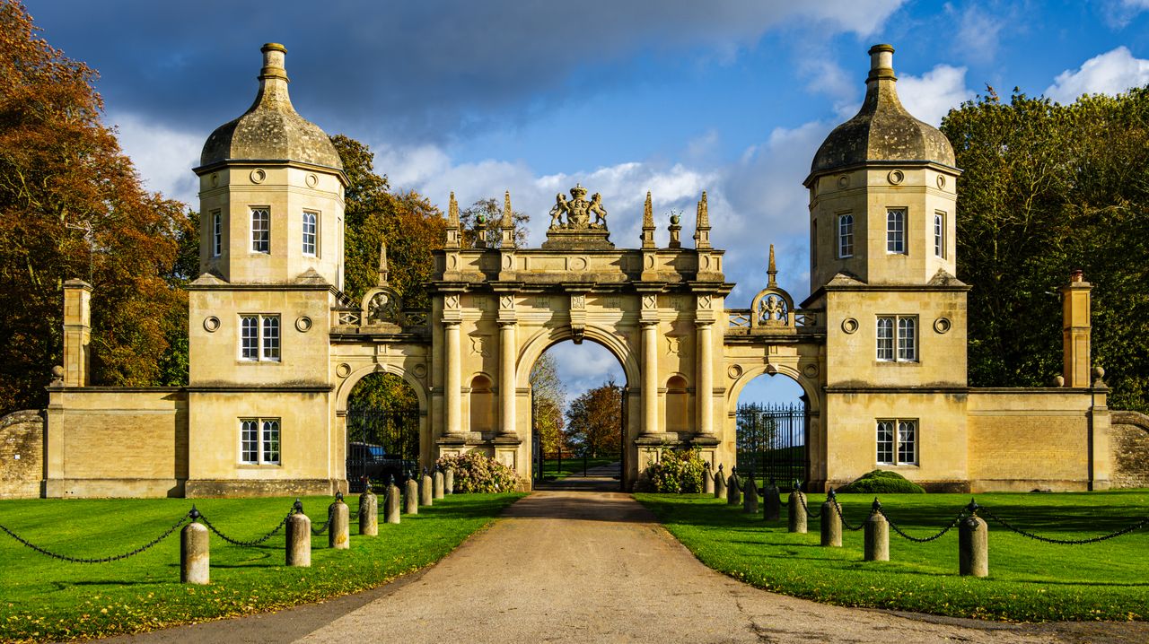 Stone estate gateway with twin domed lodges and a carved coat of arms, an area J Mould covers for demolition